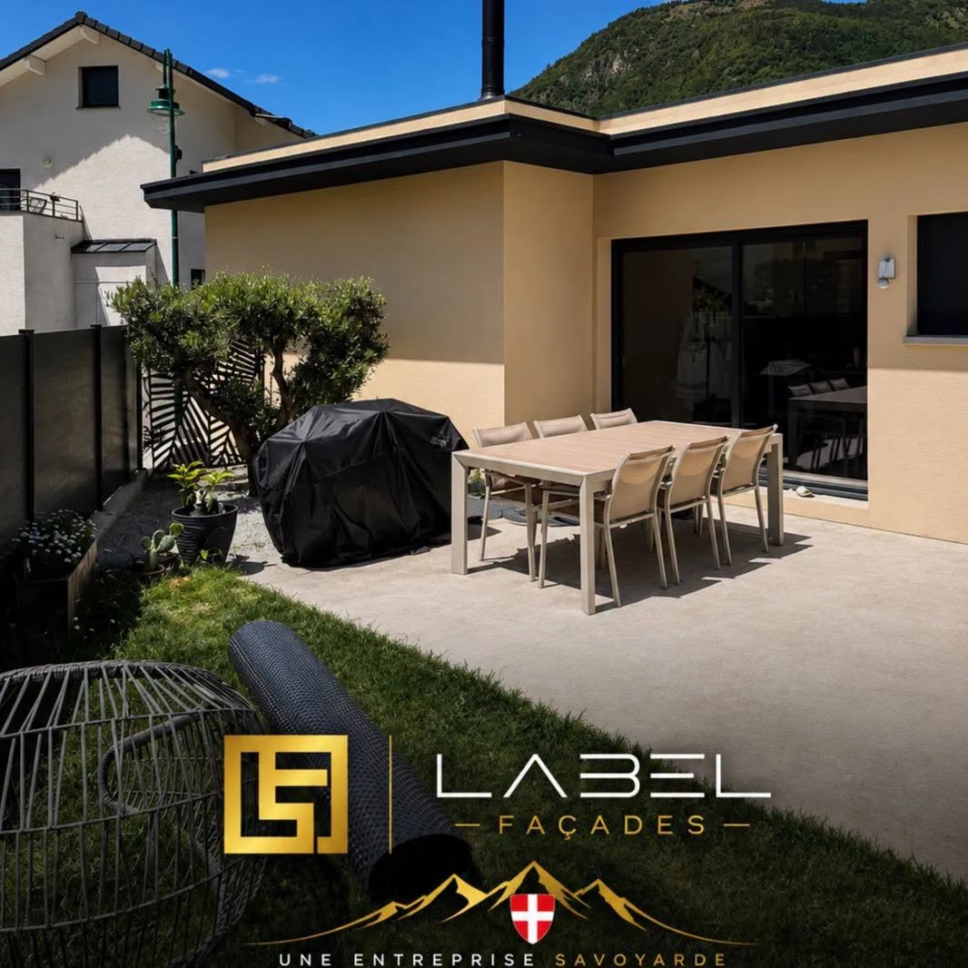 Façade beige avec une baie vitrée donnant sur une terrasse, photo Label Façades