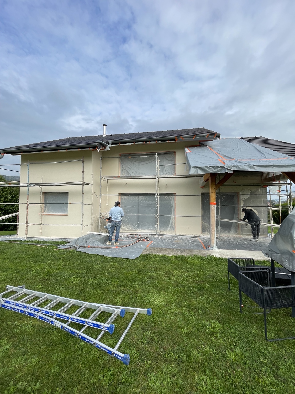 Application de l’enduit côté terrasse à Rumilly, avec menuiseries et sols protégés — Label Façades.