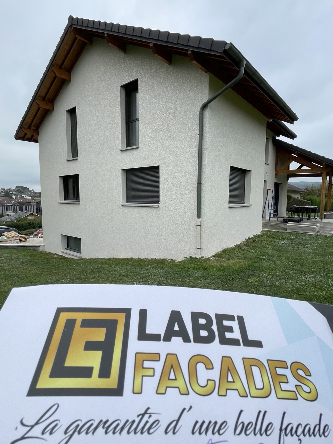 Après travaux à Rumilly : pignon en enduit clair finition écrasée et panneau Label Façades — Label Façades.