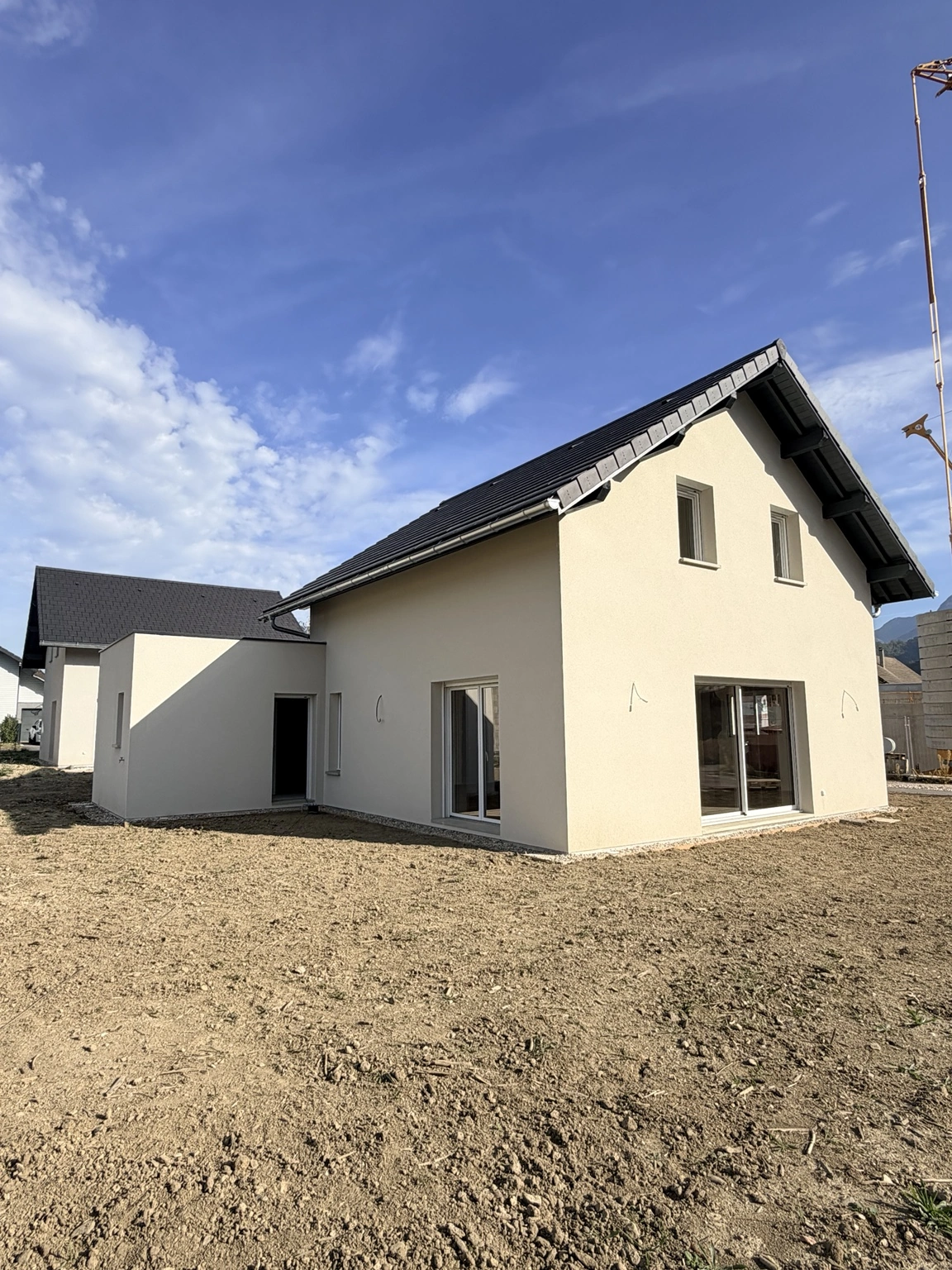 Maison neuve à Chambéry après enduit clair, avec pignon et avant-toits foncés